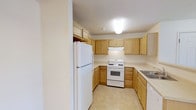 This single-floor residence offers a practical and well-organized layout across two bedrooms and two full bathrooms. The kitchen is a standout functional space, featuring a U-shaped design that maximizes efficiency and workflow. Light wood cabinetry lines the walls, providing generous storage both above and below the counters, while light-toned countertops offer ample prep space. White appliances, including a full-size refrigerator, a gas range with oven, and a dishwasher, are seamlessly integrated into the layout. The tile flooring in the kitchen is easy to maintain and complements the warm, neutral color palette throughout. Overhead flush-mount lighting keeps the space bright and practical. The two bedrooms provide comfortable retreats, while the two full bathrooms add convenience for residents and guests alike. The overall design aesthetic is clean and understated, with neutral wall tones and consistent finishes that create a cohesive feel throughout the home. This residence is well-suited for those seeking a straightforward, move-in-ready living space with all essential amenities thoughtfully included.
