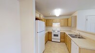 This single-floor residence offers a practical and well-organized layout across two bedrooms and two full bathrooms. The kitchen is a standout functional space, featuring a U-shaped design that maximizes efficiency and workflow. Light wood cabinetry lines the walls, providing generous storage both above and below the counters, while light-toned countertops offer ample prep space. White appliances, including a full-size refrigerator, a gas range with oven, and a dishwasher, are seamlessly integrated into the layout. The tile flooring in the kitchen is easy to maintain and complements the warm, neutral color palette throughout. Overhead flush-mount lighting keeps the space bright and practical. The two bedrooms provide comfortable retreats, while the two full bathrooms add convenience for residents and guests alike. The overall design aesthetic is clean and understated, with neutral wall tones and consistent finishes that create a cohesive feel throughout the home. This residence is well-suited for those seeking a straightforward, move-in-ready living space with all essential amenities thoughtfully included.