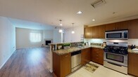 Located in the heart of Los Angeles, this 2-bedroom, 2-bathroom residence at 844 Fedora Street offers a well-designed single-level layout with a thoughtful blend of modern finishes and comfortable living spaces. The open-concept kitchen is a standout feature, equipped with rich warm-toned wood cabinetry, granite countertops, stainless steel appliances including a gas range, microwave, dishwasher, and refrigerator, along with elegant pendant lighting over a peninsula that seamlessly connects to the living area. The living room is bright and inviting, featuring wide-plank hardwood flooring, a tiled corner fireplace, and large windows with vertical blinds that allow natural light to fill the space. Both bedrooms are generously sized and finished with plush carpeting, offering a serene retreat. The two bathrooms are well-appointed with granite-topped vanities, warm wood cabinetry, and tile flooring. One bathroom features a separate glass-enclosed walk-in shower alongside a soaking tub, while the second includes a tub-shower combination. Recessed lighting throughout the home adds a clean, modern touch, and the neutral color palette creates a versatile backdrop suited to a variety of interior styles.