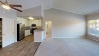 Located at 26371 Paloma in Lake Forest, CA, this single-story residence offers a thoughtfully designed layout with a welcoming open-concept living and dining area at its heart. The living room impresses with soaring vaulted ceilings, crown molding, and a ceiling fan, all centered around a tile-surround fireplace that adds warmth and character. Plush carpeting flows through the living spaces, while wood-look flooring defines the kitchen and wet areas, creating a clean visual distinction throughout.

The kitchen is well-appointed with white shaker-style cabinetry, gray countertops, a full suite of stainless steel appliances including a refrigerator, range, microwave, and dishwasher, and a peninsula that connects seamlessly to the main living area. A built-in shelving unit provides additional storage and display space adjacent to the living room.

The bedrooms are generously proportioned, each featuring plush carpet, vaulted or elevated ceilings, and natural light through large windows fitted with blinds. Closets with sliding or hinged doors offer ample storage in each room.

The bathrooms are clean and functional, featuring white cabinetry, gray countertops, large mirrors, and a combination tub and shower. The primary bathroom includes a dual-sink vanity with wood-look flooring, adding an elevated touch to the overall design.