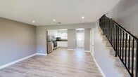 Located at 3151 Thurber Ln in Santa Cruz, California, this two-story, two-bedroom, two-bathroom home offers a well-designed layout spread evenly across two floors. Light wood-style flooring runs throughout, complemented by neutral gray walls and clean white trim, creating a cohesive, modern aesthetic.

The main level houses the kitchen and living area. The kitchen is outfitted with stainless steel appliances — including a full-size refrigerator and gas range — white shaker-style cabinetry, a under-cabinet range hood, and dark countertops that provide a stylish contrast. Recessed lighting brightens the space effectively.

Two bathrooms serve the home. One features a white vanity with a single-basin sink, stone-toned countertop, and a large mirror, while the second includes a glass-enclosed walk-in shower with white tile surround and brushed gold fixtures.

Both bedrooms are comfortably sized with neutral tones and light flooring. The primary bedroom, the larger of the two, includes multiple closet doors and access to a private outdoor balcony through a sliding glass door — offering views of the surrounding landscaping. The second bedroom features a window with garden views, bringing in natural light. A dedicated closet and hallway complete the upper level's functional layout.