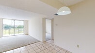 Located at 9020 NW Eighth St in Miami, Florida, unit 316 is a single-floor residence offering a practical and straightforward layout. The main living area features light-toned tile flooring that transitions to carpet in the adjacent spaces, creating a clear delineation between zones. A pendant light fixture hangs overhead, and a sliding glass door or large window along one wall allows natural light to filter in while providing views of the surrounding greenery.

The kitchen is equipped with white cabinetry featuring decorative hardware, light-toned countertops, a stainless steel sink, and a white electric range, along with ample upper and lower cabinet storage. A pass-through window connects the kitchen to the living area, enhancing the sense of openness.

The bedrooms are carpeted and feature neutral walls, louvered bi-fold closet doors offering generous storage space. One bedroom benefits from a large window with an outdoor view, filling the room with natural light.

The bathrooms include vanities with speckled countertops, white undermount sinks, chrome fixtures, and large wall-spanning mirrors with sliding panels. One bathroom showcases tile work with decorative accent detailing. Throughout, the unit maintains a clean, neutral palette suited for a variety of uses.