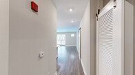 Located at 7131 Arlington Rd in the heart of Bethesda, MD, this well-appointed 2-bedroom, 2-bathroom unit offers a thoughtfully designed single-level layout. The entry hallway, featuring hardwood-style flooring and louvered closet doors, leads into an open-concept kitchen and living area filled with natural light from large glass doors. The modern kitchen is a standout, showcasing white shaker cabinetry, a glass tile backsplash, quartz countertops, a center island, stainless steel appliances including a gas range and French door refrigerator, and stylish pendant lighting. The living area extends naturally from the kitchen, creating a cohesive and functional shared space. Both bedrooms offer plush carpeting and neutral wall tones, with the generously sized primary bedroom providing ample space for comfortable living. The second bedroom features hardwood-style flooring and a small window for natural light. The bathrooms are finished with clean, classic tile work, including a tub-shower combo with white subway tile accents and chrome hardware. Throughout the unit, recessed lighting, neutral color palettes, and clean architectural lines contribute to a bright, modern, and move-in-ready ambiance.