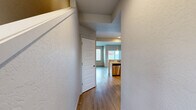 Located at 55 E Maryanna Ln in Hayden, Idaho, this two-story home offers a practical and comfortable layout across two well-defined floors. The main level features a welcoming hallway with warm wood-look flooring that extends into the open living and kitchen areas. The living room is highlighted by a tile-surround corner fireplace and a window that fills the space with natural light. The kitchen is equipped with white cabinetry, light countertops, tile backsplash, and a full suite of stainless steel appliances including a refrigerator, range, microwave, and dishwasher. A dedicated laundry room with a full-size washer and dryer adds everyday convenience. Three bathrooms are distributed throughout the home, including one with a tub-shower combination and light tile flooring. Upstairs, two bedrooms feature plush carpeting, and both include walk-in closets outfitted with wire shelving systems for ample storage. The primary bedroom is generously proportioned, offering a comfortable retreat. An attached garage with an automatic opener provides secure parking and additional storage space. The home's textured interior walls and neutral color palette create a clean, move-in-ready aesthetic throughout.
