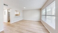Located at 5870 56th Ave N in Kenneth City, FL, this single-floor, one-bedroom, one-bathroom unit offers a well-organized and efficiently designed layout. The living room is the largest open area, featuring light hardwood-style flooring, neutral beige walls, and a textured ceiling. Natural light enters through a window fitted with blinds, and a pass-through opening connects the living space directly to the kitchen, which is equipped with white cabinetry and a stainless steel refrigerator. The kitchen's pass-through counter also serves as a convenient bar-style surface. The bedroom is a well-proportioned space with the same light flooring and soft neutral tones, offering a closet with louvered bi-fold doors and a window with exterior views. A dedicated closet provides additional storage, while the utility room accommodates functional household needs. The bathroom features a full-sized soaking tub with a white tiled surround, maintaining the clean, minimal aesthetic found throughout. HVAC vents are present in multiple rooms, ensuring climate control. The overall ambiance is bright, clean, and move-in ready, with a cohesive neutral color scheme and updated finishes throughout.
