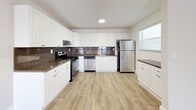 Located at 3847 NE 168th St in North Miami Beach, FL, this single-story 2-bedroom, 2-bathroom home offers a clean, modern aesthetic with consistent light wood-look flooring throughout. The open living room is bathed in natural light from a sliding glass door that opens to an outdoor view, creating an airy and welcoming atmosphere. The well-appointed kitchen features white shaker-style cabinetry, dark granite countertops, a rich tile backsplash, and a full suite of stainless steel appliances including a range, dishwasher, and refrigerator. Both bedrooms are comfortably sized, with the spacious primary bedroom offering generous closet storage. Ceiling fans are present in the bedrooms for added comfort. A dedicated walk-in closet provides ample wire-rack shelving for organized storage. The second bedroom includes louvered bi-fold closet doors and its own ceiling fan. Both bathrooms are finished with white cabinetry, dark granite countertops, and tub-shower combinations with classic tile surrounds. Natural light filters into the bathrooms via windows, keeping them bright. Neutral wall tones and clean white trim carry throughout, giving the home a cohesive and move-in-ready feel.