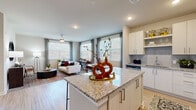 Located at 900 Elm Grove Ave in Gainesville, Georgia, this single-floor residence offers a thoughtfully designed open-concept layout with contemporary finishes throughout. The kitchen is a standout feature, equipped with stainless steel appliances, crisp white cabinetry, a tile backsplash, granite countertops, and a central island that flows seamlessly into the living and dining areas. The living space is bright and welcoming, benefiting from multiple large windows dressed with sheer curtains and blinds that allow generous natural light to fill the room. A dedicated dining area with a large window provides a pleasant setting for meals. The bedrooms are well-proportioned, each featuring ceiling fans, wood-look flooring, and ample natural light. The primary bedroom connects to a bathroom appointed with granite countertops, white cabinetry, and tile work. A spacious walk-in closet with wire shelving and multi-level hanging rods offers exceptional storage capacity. The hallways are clean and wide, finished with wood-look flooring and paneled white doors. Throughout the residence, a neutral color palette of soft grays and whites creates a cohesive, modern aesthetic that is both functional and inviting.