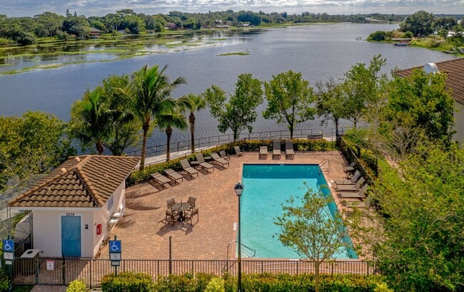 Relax by the pool with serene lake views and tropical surroundings. - Bridgewater at Lake Osborne