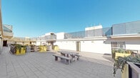 Located at 1539 Beloit Ave in the desirable West Los Angeles neighborhood of 90025, this rooftop common area offers residents an open-air retreat with sweeping views of the surrounding cityscape under Southern California's abundant sunshine. The expansive rooftop terrace is finished with large-format slate-toned pavers that lend a clean, modern aesthetic to the outdoor space. A picnic table with attached bench seating serves as a central gathering point, providing an ideal setting for outdoor dining or casual socializing. The surrounding parapet walls are topped with metal railing accents, offering both safety and an architectural design element that complements the building's contemporary white stucco exterior. Lush potted greenery adds a touch of natural color to the otherwise sleek, minimalist rooftop environment. Access to the rooftop is provided via a stainless steel elevator finished with polished doors, framed by stone-look tile walls and dark slate flooring in the elevator lobby. A heavy-duty dark metal stairwell door adjacent to the elevator offers an additional access point. Together, these features make this rooftop a well-appointed, functional, and stylish amenity space in the heart of West Los Angeles.