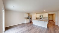 Located at 1157 Gridgeford Drive in Conway, South Carolina, this single-story home offers a thoughtfully designed layout with four bedrooms, three bathrooms, and a convenient attached garage. The open-concept kitchen and living area serves as the heart of the home, showcasing light wood-look flooring, recessed lighting, and a seamless flow throughout. The kitchen is outfitted with white shaker-style cabinetry, granite countertops, stainless steel appliances including a French door refrigerator, built-in microwave, and range, as well as a central island that doubles as a breakfast bar. The bedrooms are bright and airy, with large windows that invite natural light and offer views of the surrounding greenery. The primary bedroom features a generous walk-in closet equipped with wire shelving for ample storage. The bathrooms echo the home's clean aesthetic with white cabinetry, granite countertops, and tub-shower combinations. A dedicated laundry room houses a full-size front-loading washer and dryer with overhead wire shelving. The spacious two-car garage includes recessed lighting and an automatic opener. Neutral tones and consistent flooring throughout create a cohesive, move-in-ready atmosphere.