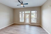 Located at 12401 Boulder Springs Pkwy in Maryland Heights, Missouri, this single-level residence offers 2 bedrooms and 3 bathrooms with a thoughtfully designed open floor plan. The combined kitchen and living room serves as the heart of the home, featuring light hardwood-style flooring, neutral warm-toned walls, and a ceiling fan that enhances the airy atmosphere. A glass door with flanking windows opens to an outdoor balcony, flooding the living area with natural light and providing pleasant outdoor views. The kitchen is outfitted with crisp white shaker cabinetry, a striking dark marbled quartz island with an undermount stainless steel sink, subway tile backsplash, stainless steel appliances, and stylish pendant lighting. The spacious primary bedroom offers generous proportions with its own dedicated closet space, while the second bedroom features plush carpeting, neutral tones, and a large window with outdoor views. The three bathrooms are finished with clean, modern fixtures — including a tiled soaking tub and a separate walk-in glass shower with white tile surround. Additional conveniences include dedicated laundry, a utility room, and four closets throughout. The consistent use of light wood flooring, neutral palettes, and modern hardware creates a cohesive, move-in-ready aesthetic throughout the entire residence.