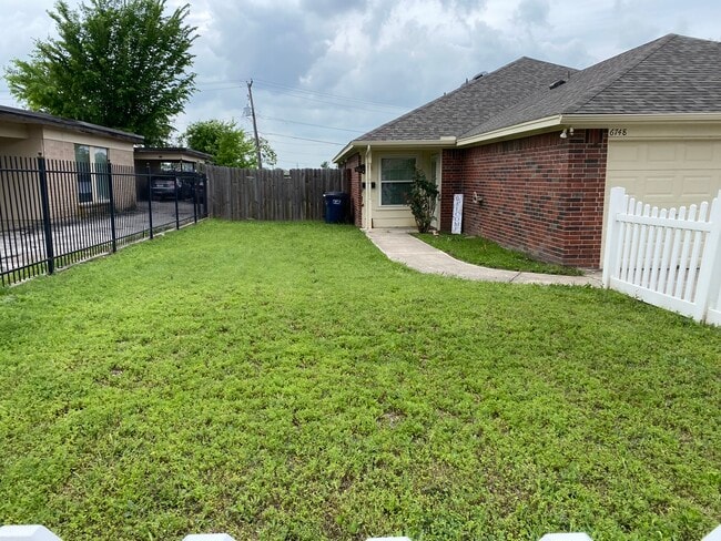 Fenced front yard. - 6748 Trail Lake Dr