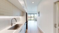 Located at 747 Hampden Ave in Saint Paul, MN, this modern studio offers a thoughtfully designed single-floor layout that maximizes every square foot. The open-concept living area is bathed in natural light, thanks to expansive floor-to-ceiling sliding glass doors that lead to a private balcony with glass-panel railings and views of the surrounding Saint Paul cityscape.

The contemporary kitchen runs along one wall and is outfitted with sleek white cabinetry, wood-toned accent panels, under-cabinet lighting, a stainless steel sink, and a full suite of stainless steel appliances including a range, dishwasher, microwave, and refrigerator. The clean white quartz countertops and minimalist hardware reinforce the space's modern aesthetic.

Warm-toned light wood flooring flows seamlessly throughout the entire unit, unifying the kitchen, living area, and hallway. The crisp white walls and recessed lighting contribute to a bright, airy atmosphere. The bathroom features a full soaking tub and shower combination, white subway-style surround, modern floating vanity with a white countertop, and matching light wood flooring. The overall design is clean, cohesive, and contemporary, making this a well-appointed urban retreat in the heart of Saint Paul.