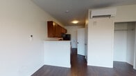 Located at 600 Marshall, this single-floor unit is designed with a clean, functional layout that maximizes usability throughout. Rich, dark hardwood flooring runs consistently through the main living areas and bedroom, lending a warm and cohesive aesthetic to the space.

The kitchen is outfitted with warm-toned wood cabinetry providing ample storage, white laminate countertops, and a full suite of black appliances including a refrigerator, electric range, over-the-range microwave, and a stainless steel sink. A peninsula counter separates the kitchen from the main living area, creating a natural division between cooking and living spaces. A wall-mounted mini-split HVAC unit ensures climate control throughout.

The bedroom is generously proportioned, featuring a built-in closet with a hanging rod for storage, a ceiling fan with integrated lighting, and a window with horizontal blinds that allows natural light to filter into the room while maintaining privacy.

The bathroom is neatly appointed with a full-size soaking tub and shower combination, chrome fixtures, safety grab bars, and light tile flooring. The vanity features a wood cabinet base complementing the overall design palette.

The unit also benefits from a dedicated entryway with a solid-panel door, providing a clear transition from the exterior into the living space.