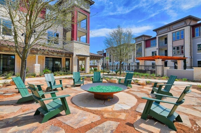 A courtyard with a fire pit and chairs - Park at Rialto Apartments