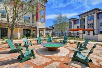 A courtyard with a fire pit and chairs - Park at Rialto Apartments