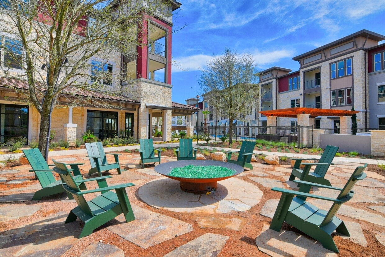 A courtyard with a fire pit and chairs - Park at Rialto Apartments