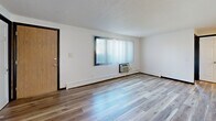 Located at 124 Capitol View Terr in Madison, WI, this single-floor, three-bedroom, two-bathroom home offers a practical and well-organized layout. Light wood-tone flooring runs consistently throughout, lending warmth and visual continuity to every room. The living room is bright and open, featuring a large window with vertical blinds that brings in natural light, alongside a wall-mounted air conditioning unit and baseboard heating. The kitchen is thoughtfully appointed with rich wood cabinetry, dark granite-style countertops, a stainless steel dishwasher, and a stainless steel range, all illuminated by a flush ceiling light panel. The three bedrooms are clean and functional, each featuring the same light wood flooring, textured ceilings, and windows fitted with horizontal blinds that allow for natural light. The primary bedroom includes a ceiling fan with integrated lighting. Closets with paneled doors provide storage in several rooms. The two bathrooms are finished in a clean, minimal style — one features a full tub/shower combo with built-in shelving and a curtain rod, while the second includes a wood-toned vanity with a framed mirror and brushed nickel fixtures. Baseboard heating is present throughout the home, and a connecting hallway ties the layout together efficiently.