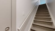 Located at 391 Schultz Rd in Buffalo, NY, this thoughtfully designed single-floor home offers 2 bedrooms, 2 bathrooms, a utility room, and a dedicated closet. The open living area greets you with light hardwood-style flooring, recessed lighting, and clean neutral walls that create a bright, airy ambiance throughout. A staircase is visible in the layout, suggesting a multi-level entry or access point, adding architectural interest to the space.

The generously sized primary bedroom is carpeted in soft, light-toned pile and features large windows with horizontal blinds that invite natural light and outdoor views. It connects to a well-organized walk-in closet equipped with wire shelving systems for versatile storage. The en-suite bathroom is finished with light hardwood-style flooring, a wide white shaker-style vanity topped with granite countertops, a large mirror, and a glass-enclosed shower.

The second bedroom is equally comfortable, with plush carpeting, neutral walls, and a window overlooking the surrounding neighborhood. The second full bathroom mirrors the quality of the primary bath, featuring a matching white vanity with granite countertops, hardwood-style flooring, and a glass shower enclosure. Throughout the home, consistent finishes and abundant natural light create a clean, modern, and welcoming environment.