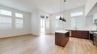 Located at 1445 Town Center Dr in Chula Vista, CA, this modern 2-bedroom, 2-bathroom residence offers a thoughtfully designed single-floor layout. The open-concept living, dining, and kitchen area serves as the heart of the home, featuring light wood-tone flooring, soaring ceilings, and an abundance of natural light streaming through large windows and clerestory windows above. A sliding glass door leads to an outdoor space, further enhancing the bright, airy atmosphere.

The kitchen is a standout, outfitted with two-tone cabinetry combining rich walnut-finished lower cabinets and crisp white upper cabinets, quartz countertops with a subway tile backsplash, stainless steel appliances, and a central island accented by sleek pendant lighting.

Both bathrooms mirror the kitchen's modern aesthetic, showcasing walnut vanities with white quartz countertops, undermount sinks, matte black hardware and fixtures, and large mirrors. The bedrooms offer plush carpeting, generous natural light, and ceiling fans. The primary bedroom includes a spacious walk-in closet with built-in shelving. A dedicated closet and two hallways add practical storage and circulation throughout the residence.