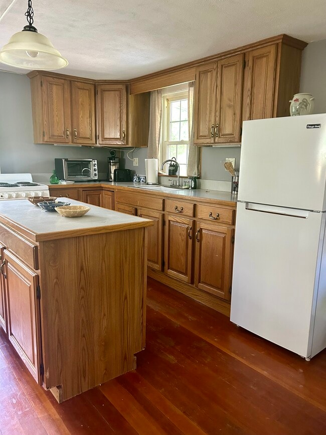 Kitchen island counter space, wooden cabinets and refrigerator - 32 Meadow St