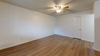 Located at 3765 N Campbell Ave in Tucson, Arizona, this single-floor unit offers a practical and well-organized layout across its living spaces. The main living area features warm wood-look vinyl flooring, textured ceilings, and a ceiling fan, creating a comfortable everyday environment. A large window allows natural light to fill the space, with vertical blinds providing privacy and light control.

The kitchen is efficiently designed in an L-shaped configuration, outfitted with light natural wood cabinetry, white appliances including a refrigerator, electric range, built-in microwave, and dishwasher, along with white countertops and a stainless steel sink. The kitchen flows naturally into the adjacent living and dining areas.

The bedrooms are carpeted for comfort and feature painted cinder block accent walls, textured ceilings, and windows with vertical blinds. One bedroom includes a ceiling fan and direct access to the bathroom, while another benefits from a large sliding glass door that invites additional natural light.

The bathroom is neatly appointed with a full tub and shower combination featuring wood-toned surround panels, a single-sink vanity with light wood cabinetry, white countertops, and wood-look flooring, offering a clean and functional finish throughout.