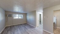 Located at 260 Oxford Dr in Winchester, Kentucky, this single-floor, one-bedroom, one-bathroom unit offers a practical and well-organized layout. Consistent light-toned hardwood-style flooring flows throughout the space, complemented by neutral gray walls and white trim, creating a clean and cohesive aesthetic. Textured ceilings add a classic touch present in nearly every room.

The living room provides an open, versatile area that connects seamlessly to the dining room and kitchen. The galley-style kitchen is efficiently designed, featuring bold dark cabinetry lining both walls, light marble-style countertops, a stainless steel sink with a matte black faucet, and full appliances including a range and refrigerator.

The bedroom offers a comfortable, private retreat with a natural window allowing outside light to fill the room, a wall-mounted AC unit, and a sliding-door closet for convenient storage. With four closets distributed throughout the unit, storage is plentiful.

The bathroom is well-appointed with a full soaking tub and shower combination, a large vanity mirror with overhead lighting, a marble-style countertop, and a dark-framed vanity cabinet consistent with the kitchen's design language. A connecting hallway ties all rooms together efficiently, making this a functional and tidy single-level home.