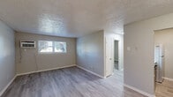 Located at 260 Oxford Dr in Winchester, Kentucky, this single-floor, one-bedroom, one-bathroom unit offers a practical and well-organized layout. Consistent light-toned hardwood-style flooring flows throughout the space, complemented by neutral gray walls and white trim, creating a clean and cohesive aesthetic. Textured ceilings add a classic touch present in nearly every room.

The living room provides an open, versatile area that connects seamlessly to the dining room and kitchen. The galley-style kitchen is efficiently designed, featuring bold dark cabinetry lining both walls, light marble-style countertops, a stainless steel sink with a matte black faucet, and full appliances including a range and refrigerator.

The bedroom offers a comfortable, private retreat with a natural window allowing outside light to fill the room, a wall-mounted AC unit, and a sliding-door closet for convenient storage. With four closets distributed throughout the unit, storage is plentiful.

The bathroom is well-appointed with a full soaking tub and shower combination, a large vanity mirror with overhead lighting, a marble-style countertop, and a dark-framed vanity cabinet consistent with the kitchen's design language. A connecting hallway ties all rooms together efficiently, making this a functional and tidy single-level home.