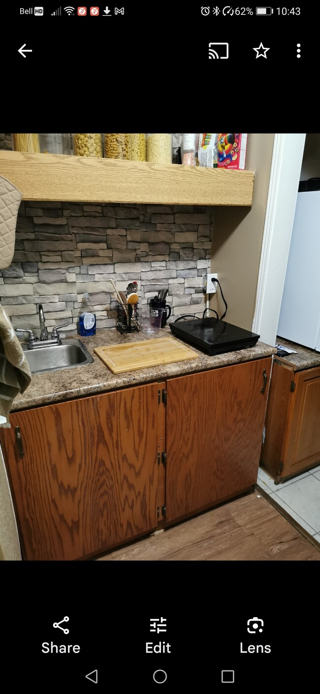 Newly added private kitchen with a medium refrigerator, stove and kitchenette with storage below - 143 Ontario St