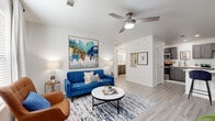 Located at 1603 W Walnut St in Rogers, Arkansas, this thoughtfully designed 2-bedroom, 1-bathroom residence offers a comfortable and modern single-floor layout. Light wood-look flooring runs throughout, creating a cohesive and airy feel across all rooms.

The open living area is bright and welcoming, featuring a ceiling fan, large windows dressed with sheer curtains, and ample space for relaxing or entertaining. The kitchen is well-appointed with dark gray shaker-style cabinetry, white quartz countertops, stainless steel appliances including a refrigerator, range, microwave, and dishwasher, and a breakfast bar peninsula ideal for casual dining.

The primary bedroom is a comfortable retreat with a ceiling fan, natural light from a window with curtain panels, and generous floor space. The second bedroom offers flexibility, accommodating both sleeping and workspace needs. Both rooms feature the same light flooring and clean white walls that define the unit's modern aesthetic.

The bathroom is finished with a dark gray vanity, white quartz countertop, a combined tub and shower, and a window that brings in natural light. Clean lines and neutral tones throughout give this residence a polished, move-in-ready appeal.
