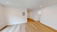 Located at 399 Erbes Rd in Thousand Oaks, CA, this thoughtfully updated 2-bedroom, 1-bathroom single-floor unit offers a clean, modern aesthetic throughout. Light-toned wood flooring flows seamlessly across every room, creating a bright and cohesive feel. The open living and dining area is generously proportioned, with recessed lighting, a wall-mounted mini-split unit for climate control, and direct access to an outdoor area via a paneled entry door flanked by a window. The kitchen is well-appointed with white shaker cabinetry, quartz countertops, stainless steel appliances including a dishwasher, range, and microwave, and a window above the sink that brings in natural light. Both bedrooms are comfortable and bright, each featuring a ceiling fan with light fixture and windows with blinds. The primary bedroom includes a mirrored sliding closet door, adding depth and functionality. A second closet provides additional storage. The bathroom is finished in a crisp black-and-white palette with white subway tile in the tub/shower surround, a quartz-topped vanity with shaker cabinets, matte black fixtures and hardware, and wood-look flooring. A hallway connects the main living areas to the bedrooms and bathroom, completing this well-organized and move-in-ready layout.
