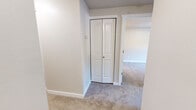 Located at 1440 Fones Rd SE in Olympia, Washington, this single-floor unit offers a functional and updated interior layout. The living room serves as a central gathering space, highlighted by a tile-surround fireplace flanked by windows fitted with vertical blinds that allow natural light to filter in. Plush carpeting and baseboard heating contribute to a comfortable atmosphere throughout the main living areas.

The galley-style kitchen is well-appointed with gray shaker-style cabinetry, white quartz countertops, a stainless steel sink, and white appliances including a coil-top range and refrigerator. Wood-look vinyl plank flooring runs through the kitchen, creating a clean contrast to the carpeted areas. A peninsula counter provides a convenient transition between the kitchen and adjacent dining or living space.

The hallway leads to the sleeping quarters, where carpeted bedrooms offer a quiet retreat, each with access to closet storage. One bedroom features a window with outdoor views and baseboard heating. The bathrooms are tastefully updated with gray vanity cabinets, white countertops, mirrored medicine cabinets, and contemporary light fixtures. Wood-look flooring in the bathrooms complements the cohesive design palette carried throughout the unit.