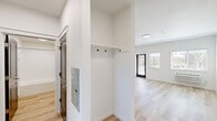 Located at 300 Hoxton Ave in Monmouth, Oregon, this thoughtfully designed 2-bedroom, 2-bathroom apartment offers a clean, modern aesthetic across its single floor. Light wood-look flooring runs throughout, creating a warm and cohesive feel in every room. The open kitchen is well-appointed with white shaker cabinetry, white countertops, a stainless steel refrigerator, range, over-the-range microwave, and a dishwasher, all illuminated by recessed lighting and a window with blinds. The adjoining living area is bright and airy, featuring large windows that invite natural light and provide views of the outdoors, along with a wall-mounted HVAC unit for year-round comfort. Both bedrooms are comfortably sized, with the primary bedroom offering generous proportions, natural light from a window, and a sliding double-panel closet with frosted glass accents and dark-finished doors. The two bathrooms each include a full tub-shower combo with brushed nickel fixtures and crisp white surrounds. Dark-finished interior doors with raised paneling add a striking contrast to the light walls and floors, lending the unit a polished, contemporary character throughout.