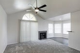 Located at 6350 Eubank Blvd NE in Albuquerque, NM, this single-story residence offers a well-designed layout with a variety of notable interior features throughout. The expansive living room immediately impresses with soaring vaulted ceilings, a ceiling fan with light fixture, and a striking arched window that floods the space with natural light. A tile-surround fireplace serves as a central focal point, while plush carpeting and vertical blinds add comfort and privacy. The living area extends into a bright bay-windowed nook, ideal as a sitting or dining area. The galley-style kitchen is thoughtfully appointed with white cabinetry, gray countertops, a white subway tile backsplash, wood-look luxury vinyl flooring, and a full suite of stainless steel appliances including a refrigerator, range, microwave, and dishwasher. The bedroom is generously sized with soft carpet, a ceiling fan, and access to a spacious walk-in closet. The bathroom features wood-look flooring, a wide vanity with gray countertop, white cabinetry, and a full tub-shower combo. A dedicated in-unit laundry area accommodates a full-size washer and dryer. The overall aesthetic is clean, neutral, and move-in ready.