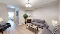 Located in San Luis Obispo, CA, this efficient one-bedroom, one-bathroom unit is thoughtfully designed to maximize comfort and functionality across a single floor. Light wood-tone flooring runs throughout, creating a cohesive and warm aesthetic in every room.

The living room serves as the heart of the unit, featuring a decorative fireplace with a gold-toned surround, neutral walls, and a chandelier overhead. Natural light filters in through a window fitted with blinds, and the open layout comfortably accommodates a full seating arrangement.

The bedroom is a quiet, well-lit retreat with multiple windows that invite natural light and offer views of surrounding greenery. The space is efficiently sized and includes room for a full bed, nightstands, and additional furniture. Coastal-inspired artwork and a calm, neutral palette give the room a restful ambiance.

The bathroom features warm wood cabinetry, a wide vanity with a large mirror framed by overhead lighting, and a shower with a curtain enclosure. The layout is clean and functional, with ample counter space for everyday essentials.

Overall, this unit offers a practical and comfortable living environment with consistent finishes, a coastal-inspired design sensibility, and a convenient single-level layout ideal for easy day-to-day living in the heart of San Luis Obispo.