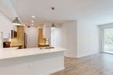 Located at 15700 SW 127th Ave in Miami, FL, this single-floor, 4-bedroom, 2-bathroom home offers a clean, modern aesthetic with thoughtful design details throughout. The open-concept living and kitchen area serves as the heart of the home, anchored by a sleek peninsula with a white quartz countertop, an undermount sink, and stylish pendant lighting. The kitchen features a blend of white upper cabinetry and warm wood-toned lower cabinets, complemented by stainless steel appliances and recessed lighting. Light wood-look flooring runs seamlessly throughout the entire home, creating a bright and cohesive feel. The bedrooms are well-proportioned and filled with natural light from large windows and sliding glass doors that offer views of the surrounding greenery. Ceiling fans are present in multiple bedrooms for added comfort. The primary bedroom includes access to a dedicated closet and an en-suite bathroom. Both bathrooms are finished with white subway tile, wood-toned vanities, and quartz countertops — one featuring a glass-enclosed walk-in shower, the other a full tub-shower combination. Two closets provide additional storage. The home's bright white walls, clean lines, and contemporary finishes give it a fresh, move-in-ready character throughout.