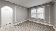 Located at 5345 Cabanne Ave in St. Louis, MO, this 2-bedroom, 1-bathroom residence offers a thoughtfully designed layout across a single floor. Light wood-style flooring flows consistently throughout the space, complemented by neutral gray walls and crisp white trim, creating a clean and cohesive aesthetic.

The kitchen is well-equipped with gray shaker-style cabinetry, granite-look countertops, a gas range, and a subway tile backsplash. Natural light enters through a window above the counter, and a door provides convenient exterior access.

The living room is a standout space, featuring elegant wall molding details and a graceful arched doorway that adds architectural character. Large windows allow generous natural light and neighborhood views, enhancing the room's openness.

Both bedrooms are comfortably sized, with the primary bedroom offering notable square footage. Each room benefits from natural light via well-positioned windows with outdoor views of the surrounding neighborhood.

A narrow hallway connects the bedrooms to the full bathroom, which is a visual highlight of the home. It features floor-to-ceiling blue-gray subway tile surrounding the tub and shower, chrome fixtures, a white vanity, and a gridded window that brings in soft natural light, creating a bright and stylish retreat.