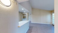 Located at 5121 Garfield Ave in Sacramento, CA, this well-appointed one-bedroom, one-bathroom residence offers a thoughtfully organized single-floor layout. The combined kitchen and living area serves as the heart of the home, featuring light wood-style flooring that flows throughout the space. Vaulted ceilings add a sense of openness to the living room, which is anchored by a tile-surround fireplace and a window that brings in natural light. A French-style door leads to a private balcony overlooking mature pine trees, providing a serene outdoor retreat. The kitchen is equipped with white shaker cabinetry, recessed lighting, a stainless sink, and black appliances including a full-size refrigerator and dishwasher. The spacious primary bedroom features vertical blinds over a sliding glass door and light wood flooring, complemented by a dedicated closet. A hallway connects the main living spaces to the bathroom, which offers a full tub-shower combination enclosed in glass sliding doors and wood-tone flooring. Warm neutral tones throughout the interior create a clean, cohesive aesthetic suited to comfortable everyday living.