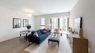 This single-floor residence offers a thoughtfully designed open-concept layout that seamlessly connects the main living areas. The living room is bright and welcoming, featuring wood-style flooring, a pendant light fixture, and large sliding glass doors that open to a balcony with outdoor views, allowing abundant natural light to fill the space. A defined dining area sits adjacent to the living room, completing the social hub of the home.

The kitchen is well-appointed with white shaker cabinetry, dark countertops, a tile backsplash, and a full suite of stainless steel appliances including a refrigerator, range, and microwave. A multi-seat island provides additional prep space and casual dining.

Two bedrooms offer carpeted flooring and a calm, neutral palette. The primary bedroom includes a spacious walk-in closet with wire shelving, while a second bedroom benefits from its own window with exterior views. Both bathrooms feature wood-style flooring, white cabinetry with dark countertops, and shower enclosures — one with a tub-shower combination, the other a standalone shower. The overall ambiance is clean, contemporary, and functional.