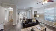 Located at 14723 W Oaks Plaza Dr in Houston, TX, this single-story residence offers a thoughtfully designed layout with modern finishes and a welcoming ambiance throughout. The open-concept living and dining area is anchored by rich hardwood-style flooring, crown molding, and a ceiling fan with light fixture. Large windows fitted with blinds allow natural light to fill the space, creating a bright and airy atmosphere. A sliding glass door provides additional access and light to the living area.

The kitchen is a standout feature, boasting granite countertops, a peninsula with bar seating, white cabinetry, and black appliances including a refrigerator, range, and microwave. The layout flows seamlessly into the living and dining spaces, making it ideal for entertaining.

The bedrooms are carpeted for comfort, each equipped with ceiling fans and windows that invite natural light. One bedroom includes a walk-in closet, offering generous storage. The neutral gray tones on the walls lend a calm, cohesive feel to each room.

The bathroom is elegantly appointed with a granite-topped vanity, a large framed mirror, and a tub-shower combination, all finished in crisp, clean tones. Throughout the residence, the consistent use of neutral palettes, quality surfaces, and thoughtful details create a polished and comfortable living environment.