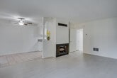 Located at 20455 Anza Ave in Torrance, CA, this single-floor residence offers a clean, neutral aesthetic throughout its well-organized layout. The living area is a welcoming space featuring light wood-style flooring, a textured ceiling, and a built-in fireplace framed by a white wood-paneled accent wall. A ceiling fan adds both style and function, while sliding glass doors provide access to the outdoors and allow natural light to fill the space. The adjoining dining and kitchen area transitions to tile flooring and includes white cabinetry, granite-style countertops, a stainless steel sink, and white appliances including a range, microwave, and refrigerator — offering a practical and tidy cooking environment. The bedrooms are carpeted for comfort, each featuring vertical blinds over sliding or standard windows that bring in soft, diffused light. The bathrooms maintain the home's clean, minimal aesthetic, with tile flooring, white vanities, large mirrors, and frosted glass shower enclosures fitted with chrome fixtures and towel bars. Throughout the home, the consistent use of white walls and neutral finishes creates a bright, cohesive atmosphere well-suited to a variety of living styles.