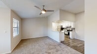 This single-floor, 1-bedroom, 1-bathroom unit offers a thoughtfully designed layout that maximizes its compact footprint. The open-concept living and kitchen area serves as the heart of the home, where vaulted ceilings and a ceiling fan create an airy, spacious feel. The living room features plush wall-to-wall carpeting and neutral-toned walls that provide a clean, versatile backdrop.

The kitchen is efficiently appointed with white shaker-style cabinetry, granite-look countertops, and a full suite of stainless steel appliances, including a refrigerator, electric range, and over-the-range microwave. Wood-look vinyl flooring runs throughout the kitchen, complementing the light and modern aesthetic. A peninsula counter connects the kitchen to the living area, enhancing both functionality and flow.

The bedroom is a comfortable, well-sized retreat with plush carpeting, a ceiling fan, a window that allows natural light, and a closet for storage. A hallway connects the private areas of the unit, leading to the full bathroom, which includes a tub/shower combination with brushed nickel fixtures. Throughout the unit, textured ceilings, clean white trim, and a neutral color palette contribute to a cohesive and move-in-ready aesthetic.