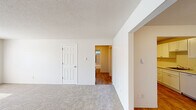 Located at 9318 S Steele St in Tacoma, WA, this single-floor residence offers a practical and comfortable layout with two bedrooms, two bathrooms, a living room, dining room, kitchen, hallway, and a dedicated closet. The spacious living room is finished with plush wall-to-wall carpeting and features a large window that invites natural light and greenery views, along with a textured ceiling and a classic six-panel front door entry. The kitchen stands out with bright white shaker-style cabinetry, light stone countertops, warm wood-look vinyl flooring, and an electric range — offering a clean, functional workspace. The primary bedroom is generously sized, carpeted, and includes a sliding closet as well as a window framing lush outdoor foliage, with baseboard heating providing year-round comfort. The second bedroom also features carpet flooring and hardwood-look accents in connecting areas. Both bathrooms are well-appointed, with one showcasing a tiled tub-and-shower surround in neutral tones and a privacy window for natural light. Throughout the residence, a consistent neutral color palette and clean finishes create a cohesive and move-in-ready atmosphere.