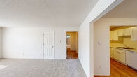 Located at 9318 S Steele St in Tacoma, WA, this single-floor residence offers a practical and comfortable layout with two bedrooms, two bathrooms, a living room, dining room, kitchen, hallway, and a dedicated closet. The spacious living room is finished with plush wall-to-wall carpeting and features a large window that invites natural light and greenery views, along with a textured ceiling and a classic six-panel front door entry. The kitchen stands out with bright white shaker-style cabinetry, light stone countertops, warm wood-look vinyl flooring, and an electric range — offering a clean, functional workspace. The primary bedroom is generously sized, carpeted, and includes a sliding closet as well as a window framing lush outdoor foliage, with baseboard heating providing year-round comfort. The second bedroom also features carpet flooring and hardwood-look accents in connecting areas. Both bathrooms are well-appointed, with one showcasing a tiled tub-and-shower surround in neutral tones and a privacy window for natural light. Throughout the residence, a consistent neutral color palette and clean finishes create a cohesive and move-in-ready atmosphere.