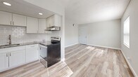 Located at 1279 Santa Rosa Street in Clearwater, FL, this single-floor, one-bedroom, one-bathroom unit offers a thoughtfully updated interior with a clean, modern aesthetic. Light wood-look flooring runs throughout, complementing the neutral gray walls and crisp white trim to create a bright, cohesive living environment.

The open-concept living and kitchen area maximizes the available space efficiently. The kitchen is well-appointed with shaker-style white cabinetry, granite countertops with subtle earthy tones, a stainless steel undermount sink, brushed nickel hardware, a classic subway tile backsplash, and a stainless steel range. A textured ceiling adds depth to the space.

The bedroom is a comfortable, well-proportioned room featuring a double bi-fold closet for ample storage, a ceiling-mounted HVAC vent for climate control, and a window that allows natural light to filter in. The room's neutral palette and wood-look flooring maintain the cohesive design found throughout the unit.

The bathroom is a standout feature, showcasing large-format marble-look wall tiles surrounding a clean white soaking tub, delivering a spa-inspired feel. A connecting hallway links the bedroom and bathroom seamlessly.

This unit's updated finishes, efficient layout, and bright interior make it a polished and practical living space in Clearwater, FL.