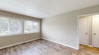 Located at 4233 Jonesboro Rd in Forest Park, Georgia, this 2-bedroom, 1-bathroom unit offers a clean, updated interior thoughtfully arranged across a single floor. Light-toned luxury vinyl plank flooring flows throughout the main living areas, kitchen, hallway, and bathroom, creating a cohesive and easy-to-maintain aesthetic.

The kitchen is a standout feature, outfitted with crisp white shaker-style cabinetry, granite-look countertops, a white subway tile backsplash, and black appliances including a gas range, refrigerator, and dishwasher. A window above the range area brings in natural light and views of surrounding greenery. The kitchen opens directly into the living room, which is brightened by a wide triple-panel window overlooking the exterior.

Both bedrooms are carpeted for comfort and feature neutral walls and multiple windows that allow natural light to pour in. The primary bedroom includes two closets, providing generous storage. The second bedroom is similarly well-lit with dual windows.

The bathroom maintains the clean aesthetic of the rest of the unit, with wood-look flooring, a full tub-shower combination, and a window for natural ventilation. A hallway connects all rooms efficiently, completing the practical and well-organized layout of this move-in-ready home.