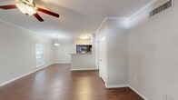 Located at 5600 Mulholland Drive in Glen Allen, Virginia, this compact yet well-designed apartment maximizes its 690 square feet of living space. The single-floor layout comprises one bedroom, one bathroom, and an open-concept kitchen and living area. The primary bedroom, measuring 200 square feet, offers ample space and is equipped with a ceiling fan and large window for natural light.

The kitchen showcases modern stainless steel appliances, including a French door refrigerator and built-in microwave. Dark wood cabinetry contrasts beautifully with the granite countertops, creating a sleek and contemporary look. A breakfast bar with granite overhang adds functionality and defines the space.

The bathroom features a full-sized tub-shower combination, modern vanity with ample storage, and wood-look flooring that complements the overall design. Throughout the apartment, rich wood-toned flooring adds warmth and continuity, while plush carpeting in the bedroom provides comfort underfoot.

Large windows in the living area and bedroom flood the space with natural light, while ceiling fans contribute to air circulation and ambiance. Crown molding and neutral wall colors add a touch of elegance to the overall design. The open floor plan creates a sense of spaciousness, making this compact apartment feel larger than its actual square footage suggests.