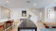 Located at 21054 Rosemary Breeze Ln in Cypress, TX, this well-appointed two-story home offers three bedrooms and four bathrooms across two thoughtfully designed floors. The ground floor hosts the open-concept kitchen and living area, anchored by a large center island with quartz countertops and bar seating — ideal for entertaining. The kitchen features white shaker cabinetry, a subway tile backsplash, stainless steel appliances including a gas range and side-by-side refrigerator, and light hardwood-style flooring that flows throughout. The living room is bright and welcoming, with warm neutral accent walls and large windows that invite natural light. A half bathroom on the main level adds everyday convenience, and the attached garage provides ample storage and parking. Upstairs, the primary bedroom is a serene retreat with soft blue accent walls, dual windows, and a ceiling fan. The walk-in closet is well-organized with built-in shelving and hanging rods. Additional bedrooms are comfortably sized with natural light. The upper-level bathrooms are finished with light-toned cabinetry, quartz vanities, and hardwood-style flooring. A backyard green space rounds out this functional and stylish home.