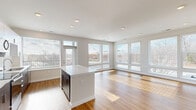 Located at 2500 Vantage Dr in Woodbridge, VA, this well-appointed single-floor residence offers 3 bedrooms, 3 bathrooms, and a thoughtfully designed open-concept layout. The combined living, dining, and kitchen area serves as the heart of the home, bathed in natural light from an impressive array of large windows along multiple walls. Warm hardwood-style flooring runs throughout the main living spaces, complementing the clean, modern aesthetic. The kitchen features a central island with a crisp white countertop, two-tone cabinetry with dark lower cabinets and white upper cabinets, stainless steel appliances including a range, microwave, and dishwasher, and a single-basin sink beneath a sun-drenched window. The primary bedroom is generously sized with hardwood-style flooring and expansive corner windows offering broad outdoor views. The two additional bedrooms are carpeted and well-lit with large windows and ceiling fans. Six closets, including walk-in options with wire shelving systems, provide ample storage throughout. The bathrooms are finished in a clean, contemporary style with white tile surrounds, soaking tubs, and sleek floating vanities. A dedicated laundry room adds everyday convenience to this modern Woodbridge residence.
