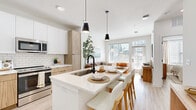 Located at 1301 Lebanon Pike in Nashville, TN, this thoughtfully designed one-bedroom, one-bathroom unit offers a bright and modern living experience on a single floor. The open-concept layout seamlessly connects the kitchen, dining, and living areas, creating an efficient and welcoming flow throughout the space.

The kitchen is a standout feature, showcasing a combination of white upper cabinetry and warm wood-toned lower cabinets, white subway tile backsplash, quartz countertops, and stainless steel appliances including a French door refrigerator, gas range, and built-in microwave. A large island with seating and sleek black pendant lighting serves as both a functional workspace and a casual dining hub.

The living room is bathed in natural light from generous windows and a glass door, complemented by light wood-look flooring that runs throughout the unit. A built-in entry nook with open shelving adds practicality near the front entrance.

The bedroom is a calm retreat with natural light from a window, a ceiling fan, and ample room for a comfortable furniture arrangement. The bathroom features a wood-vanity with white countertop, large-format tile flooring, black accent fixtures, and direct access to a walk-in closet, rounding out this well-designed Nashville residence.